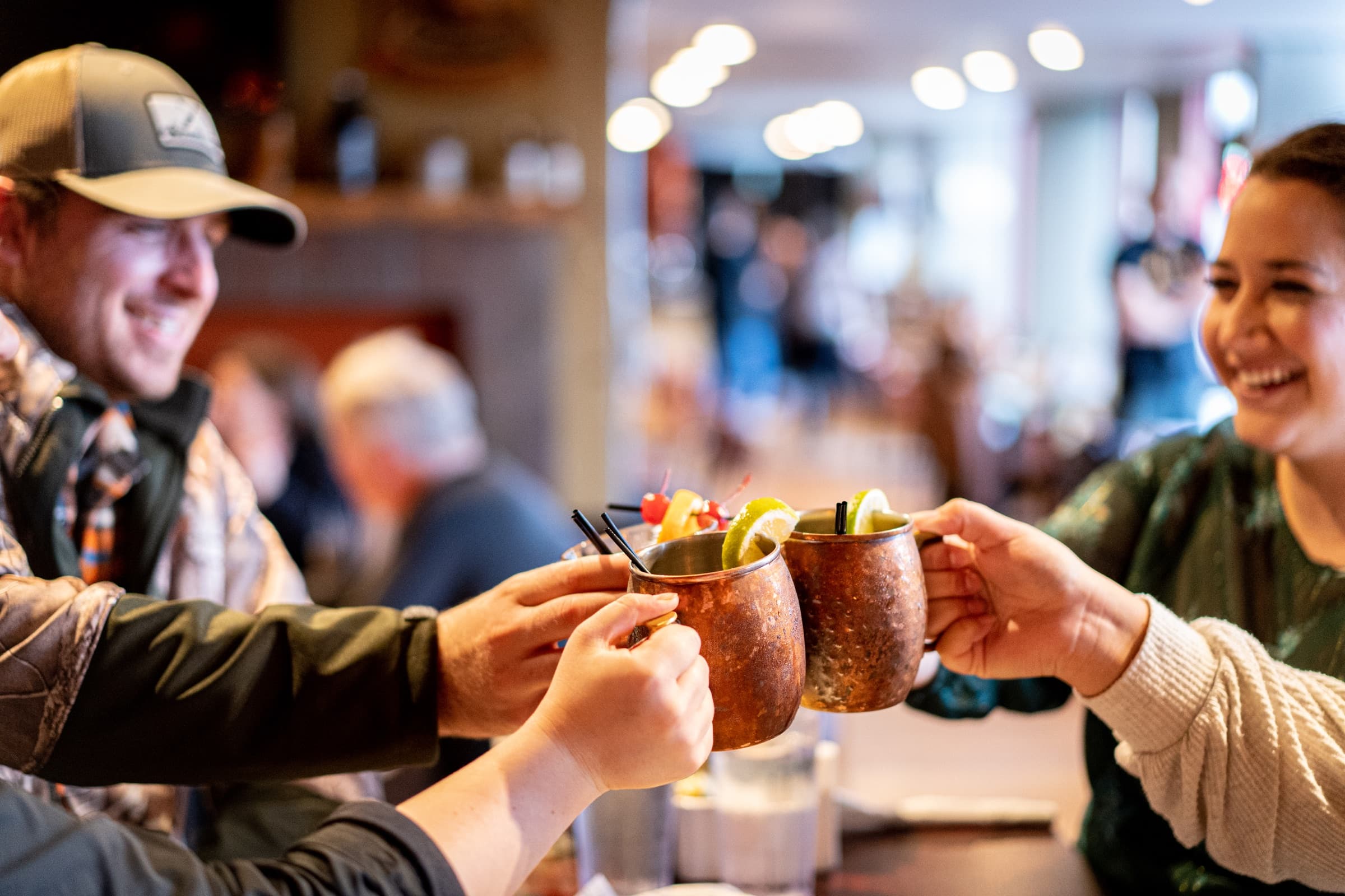 Guests toasting copper mugs at Bayview Pub.